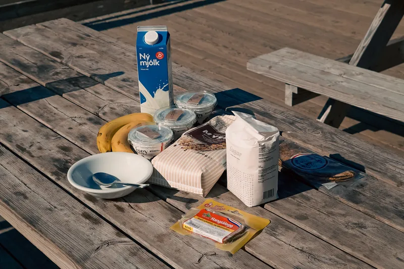Skyr, milk, bananas and packaged groceries arranged for an outdoor breakfast in Iceland