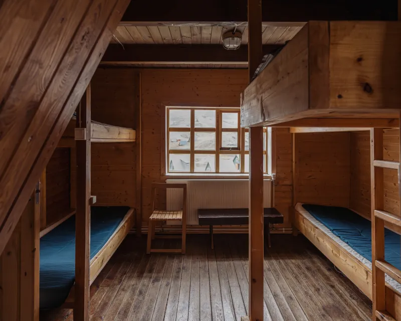 Shared wooden bunk beds with mattresses inside the Kerlingarfjöll hut