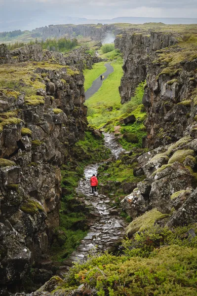 Walking path between rocky rift walls at Þingvellir National Park