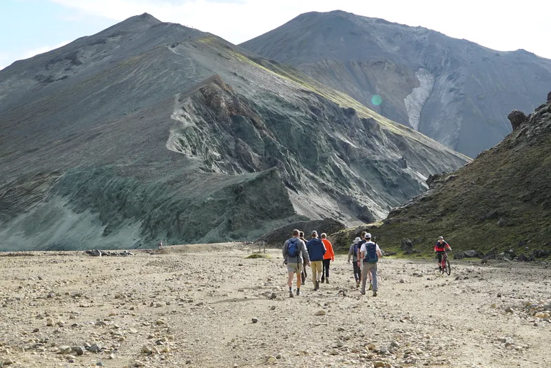 Hikers approaching the volcanic slopes of Bláhnúkur in Landmannalaugar