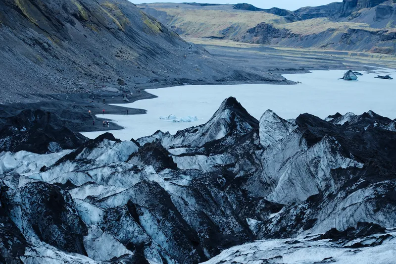 Ash-striped ice ridges and the meltwater lake at Sólheimajökull glacier