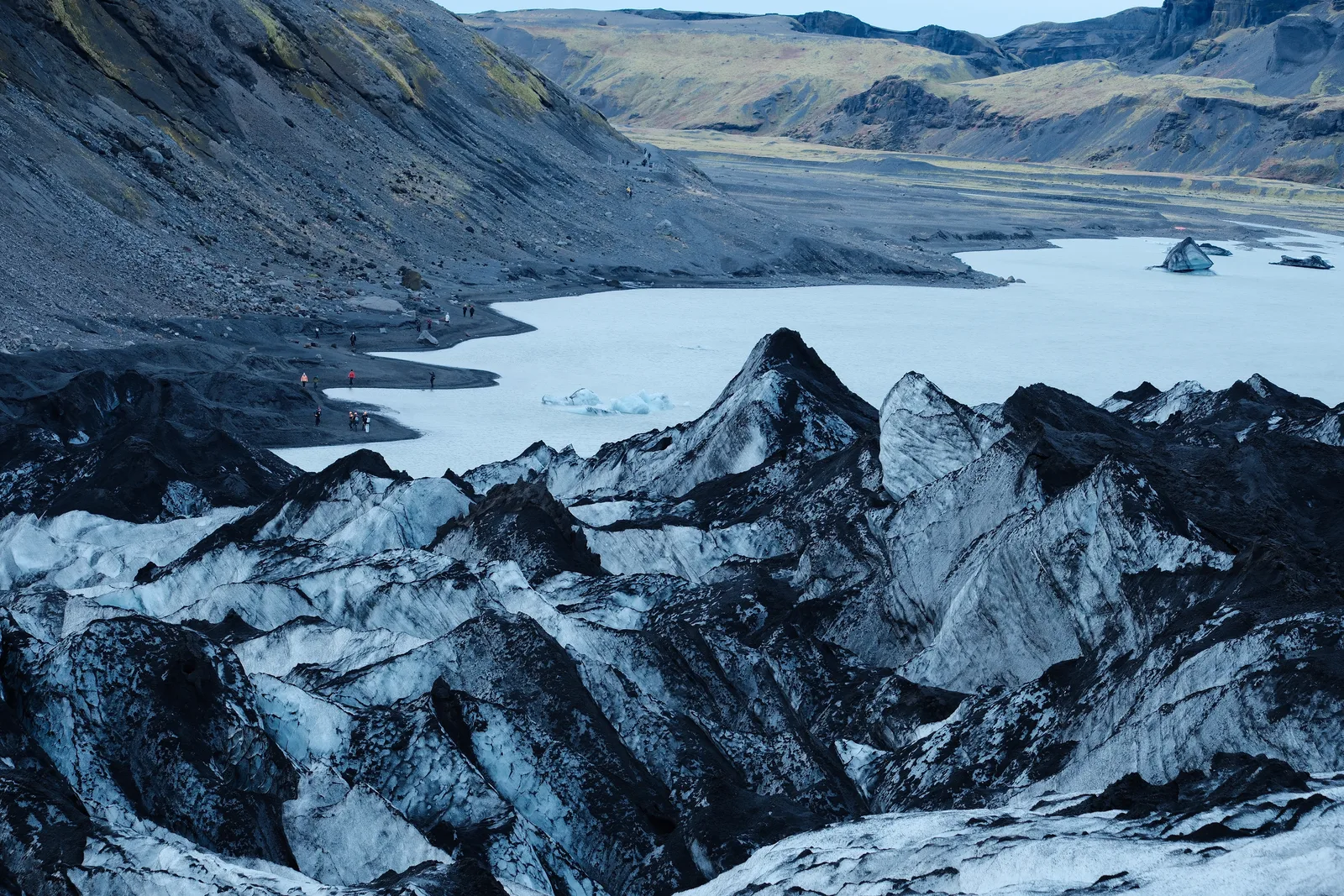 Ash-striped ice ridges above the meltwater lake at Sólheimajökull glacier