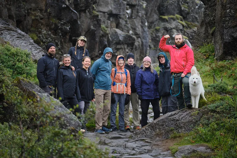 Hikers and a white dog in the Þingvellir rift